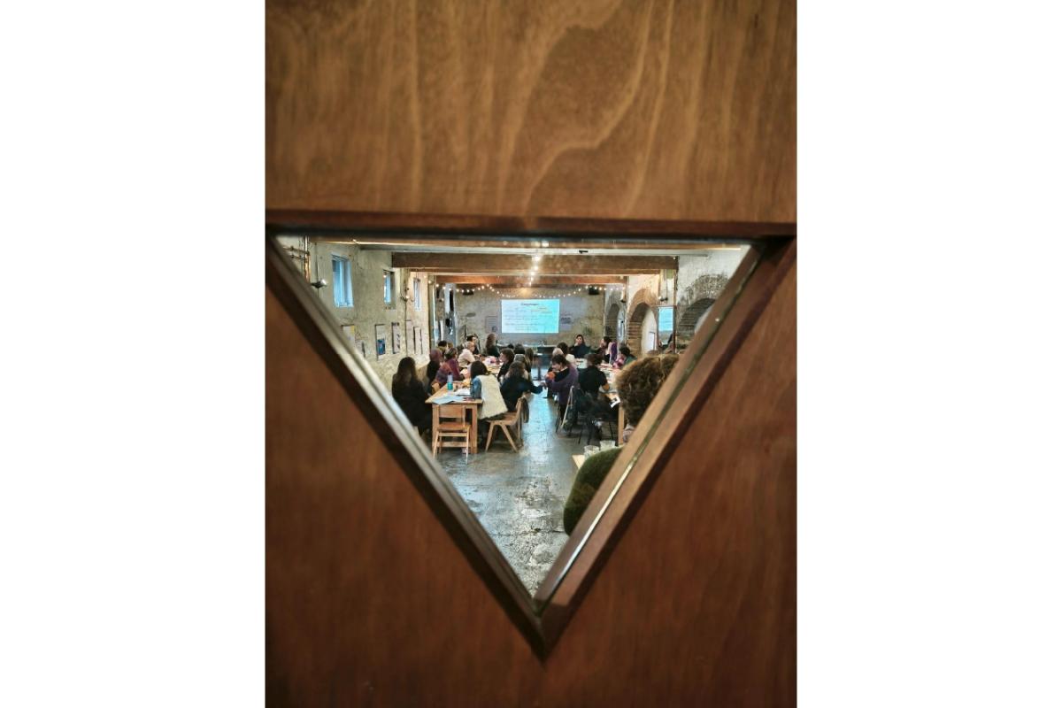 people sitting at tables seen through a door